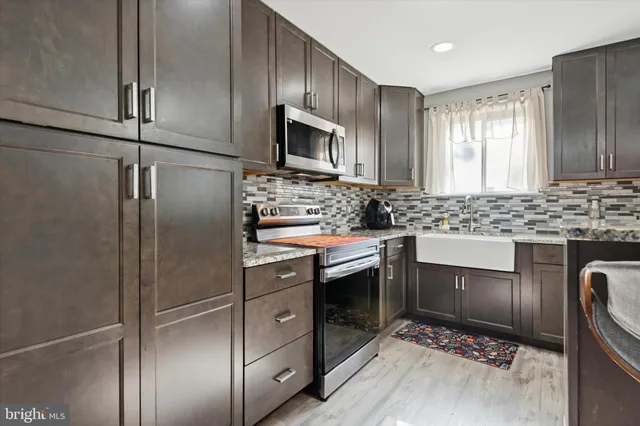 a kitchen with stainless steel appliances granite countertop a refrigerator stove and sink