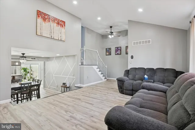 a living room with furniture and a dining table with kitchen view
