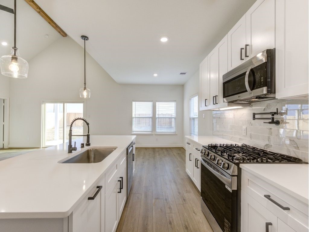 140 County Road 2278 Cleveland, TX 77327 - Photo 2 of 10 a kitchen with kitchen island granite countertop a sink stainless steel appliances and cabinets