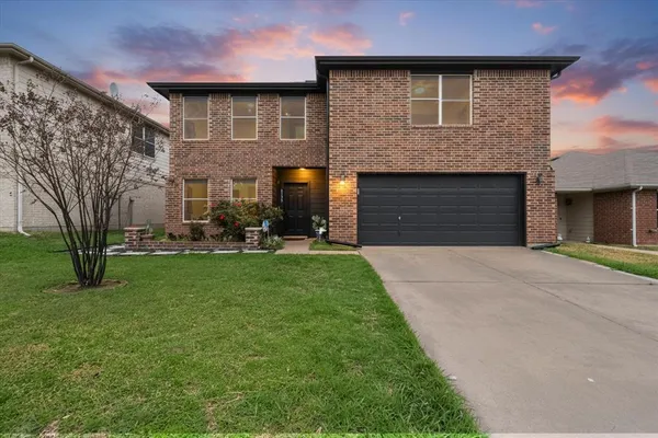 a front view of a house with a garden and yard