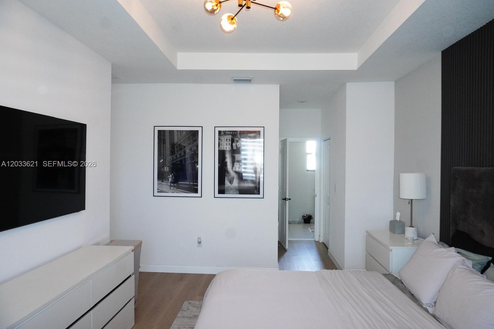11942 Southwest 243rd Street Homestead, FL 33032 - Photo 17 of 50 a bedroom with a bed and a flat screen tv