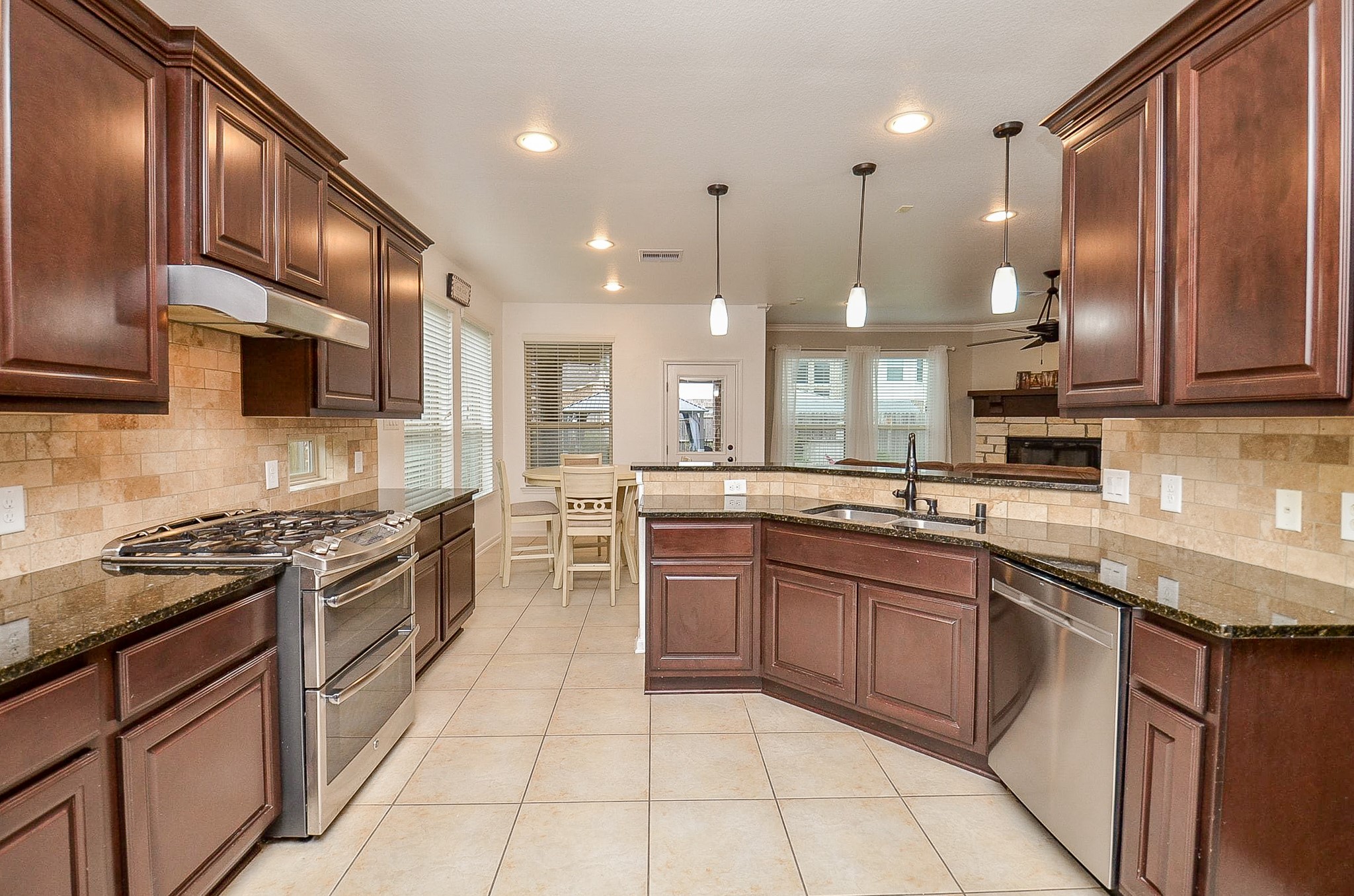 1510 Kent Valley Lane Rosenberg, TX 77471 - Photo 8 of 33 a kitchen with stainless steel appliances granite countertop wooden cabinets a stove a sink and a refrigerator