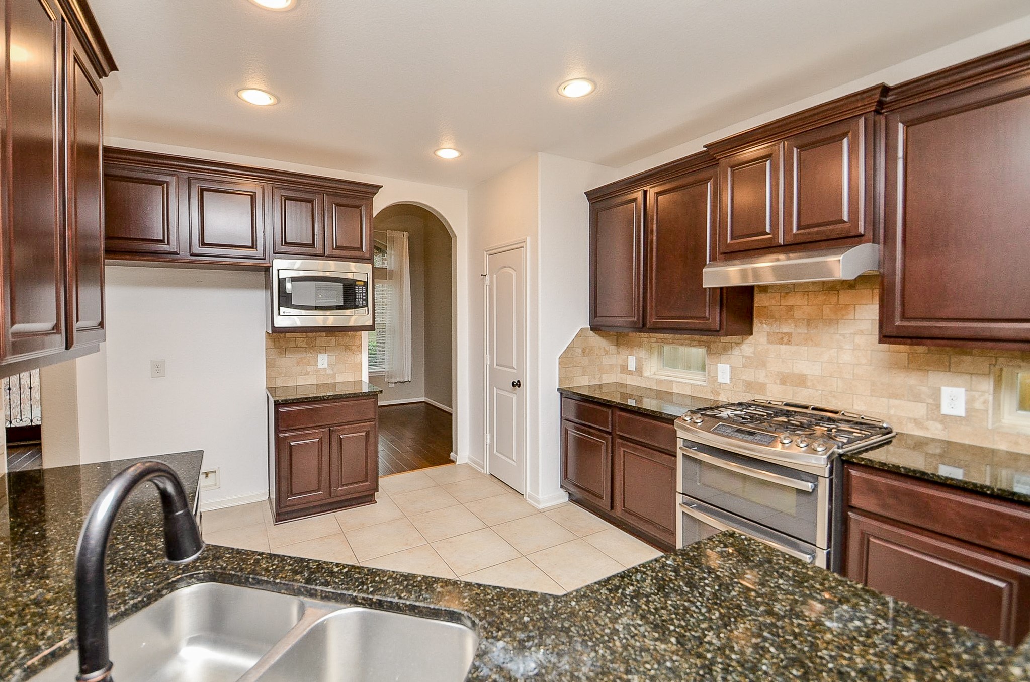 1510 Kent Valley Lane Rosenberg, TX 77471 - Photo 9 of 33 a kitchen with stainless steel appliances granite countertop a stove top oven a sink and dishwasher