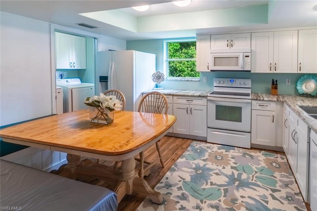 1031 Ridge Street Naples, FL 34103 - Photo 8 of 38 Kitchen with white appliances, washing machine and dryer, light stone countertops, a tray ceiling