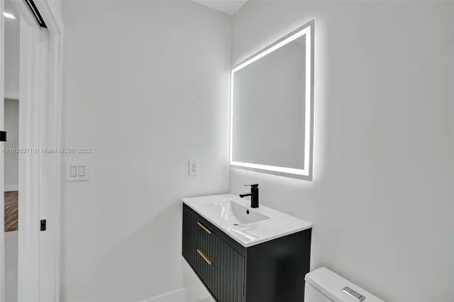 a bathroom with a sink toilet and mirror