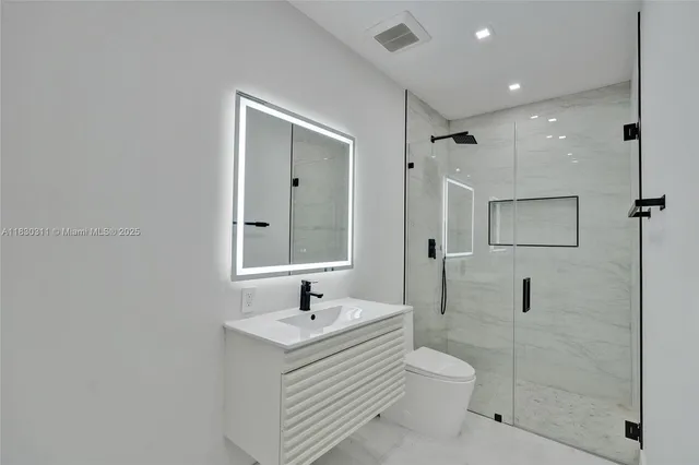 a bathroom with a toilet sink a shower and mirror