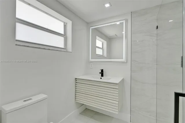 a bathroom with a sink a toilet and a mirror