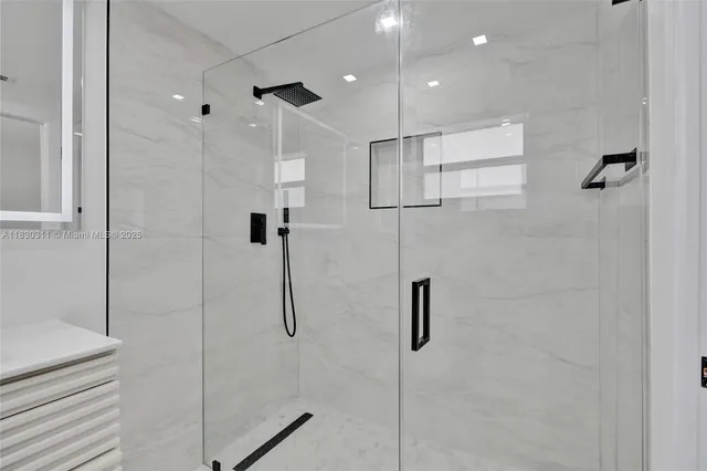 a bathroom with a shower and a glass door