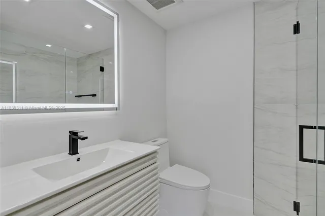 a bathroom with a sink toilet and shower