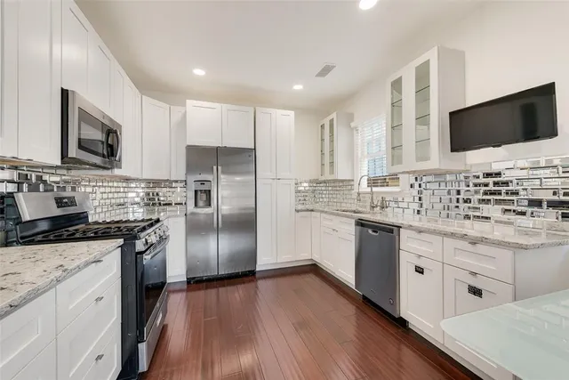 a kitchen with stainless steel appliances a stove sink microwave and refrigerator