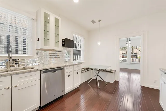 a kitchen with stainless steel appliances granite countertop a sink cabinets and wooden floor