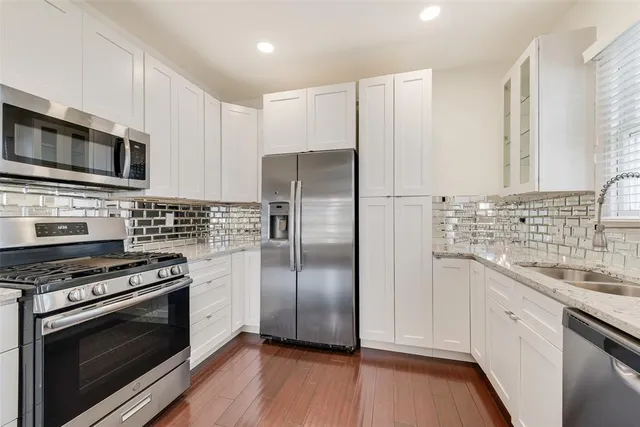 a kitchen with stainless steel appliances a stove a sink and a microwave