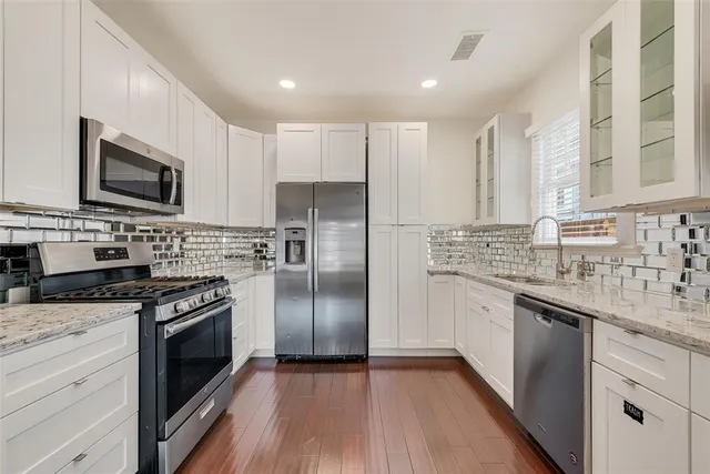 a kitchen with stainless steel appliances granite countertop a refrigerator stove microwave and sink