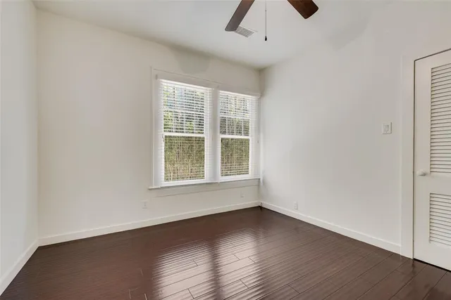 an empty room with a window and a ceiling fan