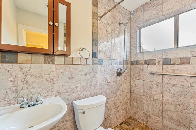 a bathroom with a toilet sink and mirror