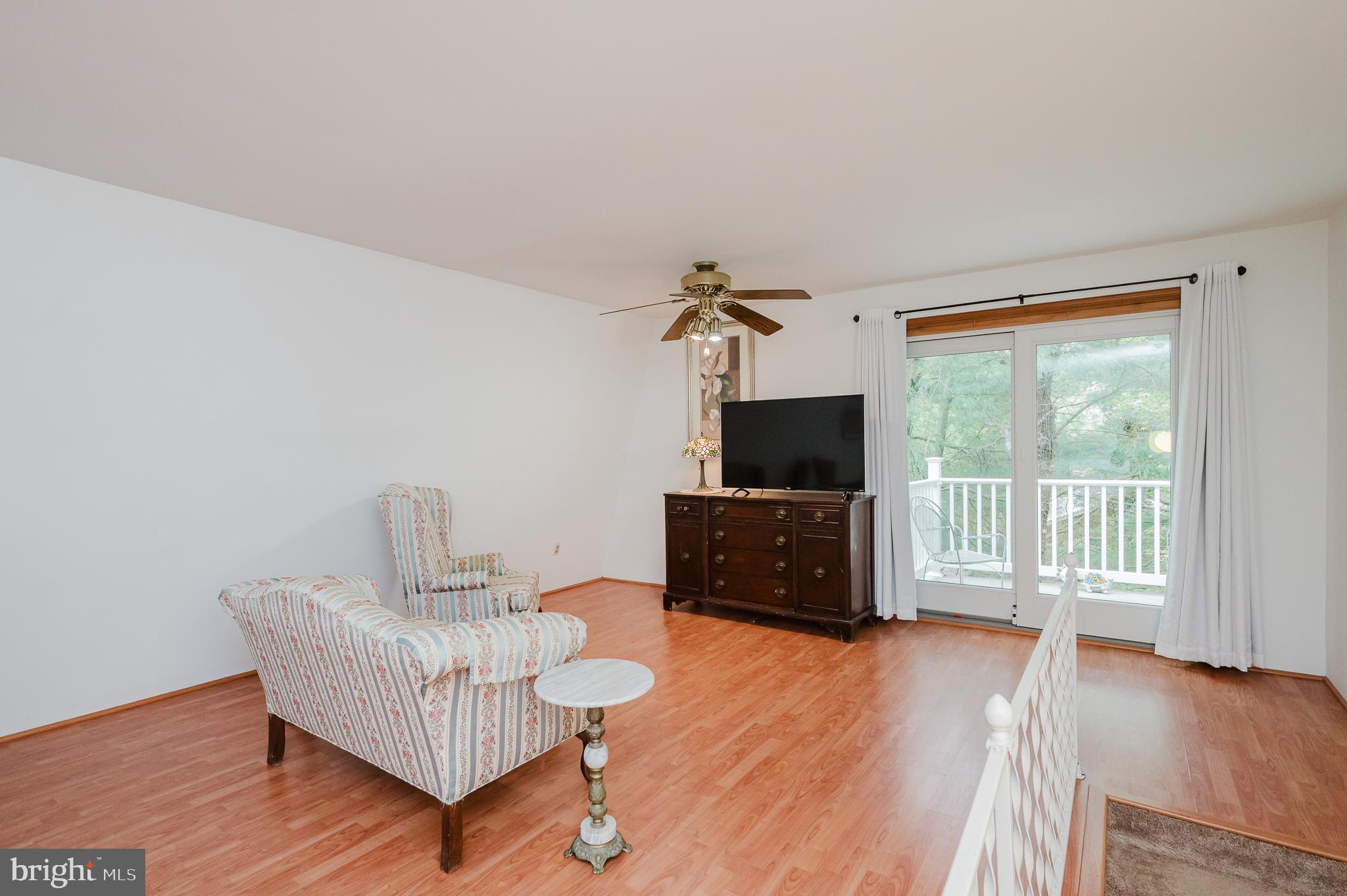 710 Magnolia Road Joppa, MD 21085 - Photo 25 of 58 a living room with furniture a flat screen tv and a floor to ceiling window