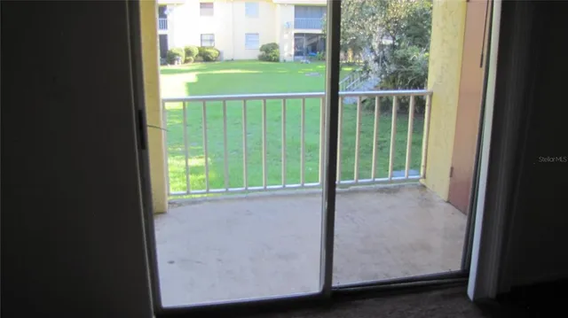 a view of a glass door with a yard from a window