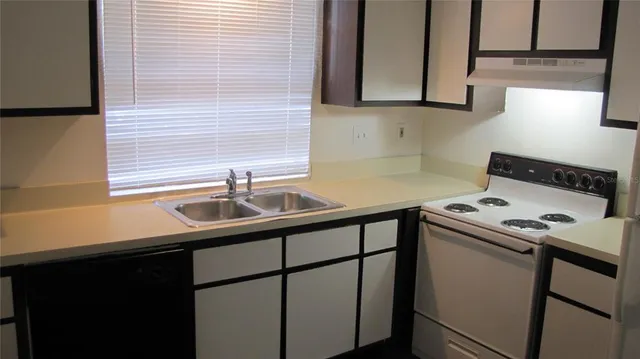 a kitchen with a sink stove and cabinets