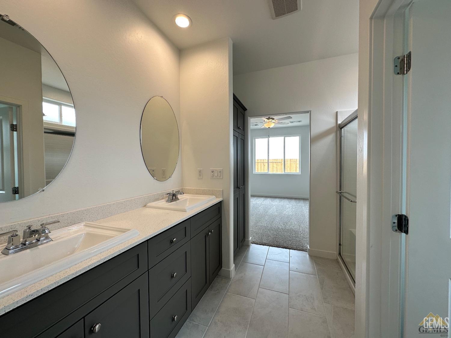 Undisclosed Address Bakersfield, CA 93311 - Photo 2 of 7 a en suite bathroom with a double vanity sink and a mirror