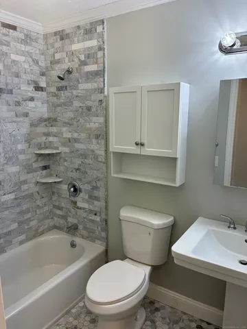 a white toilet sitting next to a bath tub