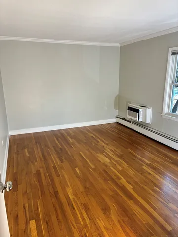 a view of a room with wooden floor and a window