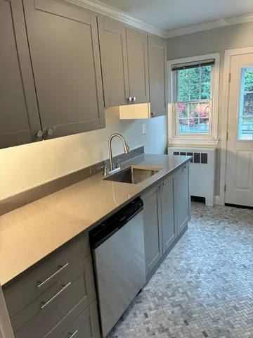 a kitchen with a sink cabinets and window
