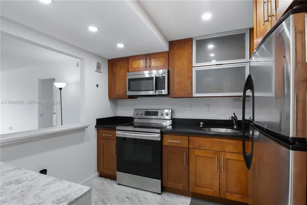 a kitchen with stainless steel appliances granite countertop a stove a sink and a refrigerator
