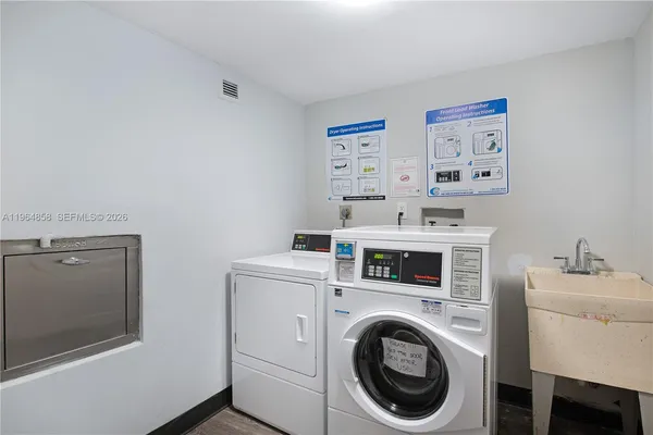 a utility room with dryer washer and a view of living room