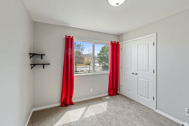 444 South Saddle Road Grantsville, UT 84029 - Photo 8 of 33 Unfurnished bedroom with light colored carpet and a closet
