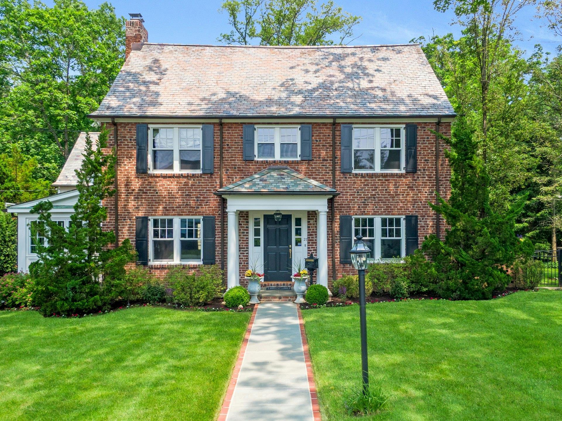 a front view of a house with a garden and plants