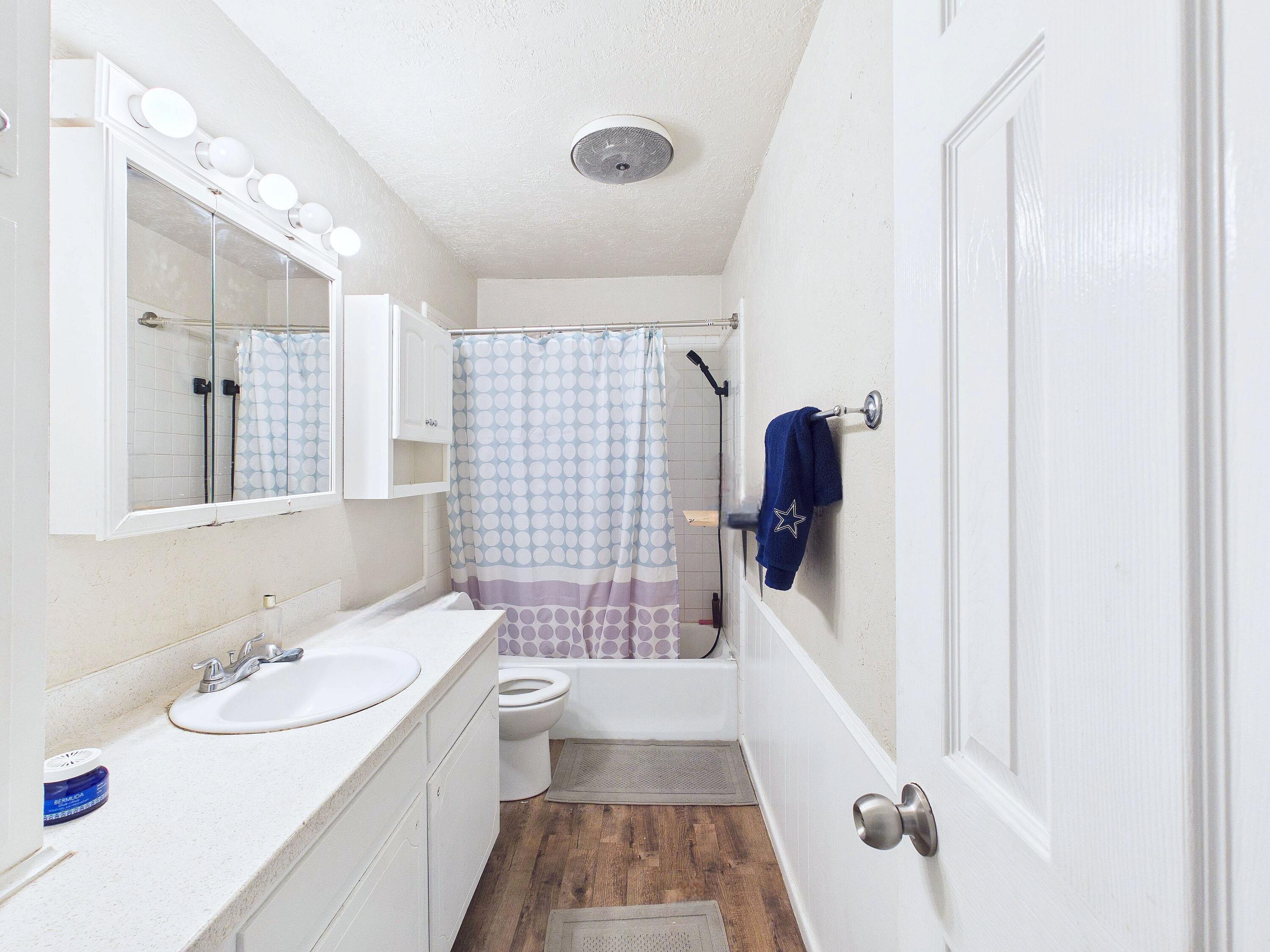 4825 10th Street Lubbock, TX 79416 - Photo 14 of 27 a bathroom with a sink a tub and shower