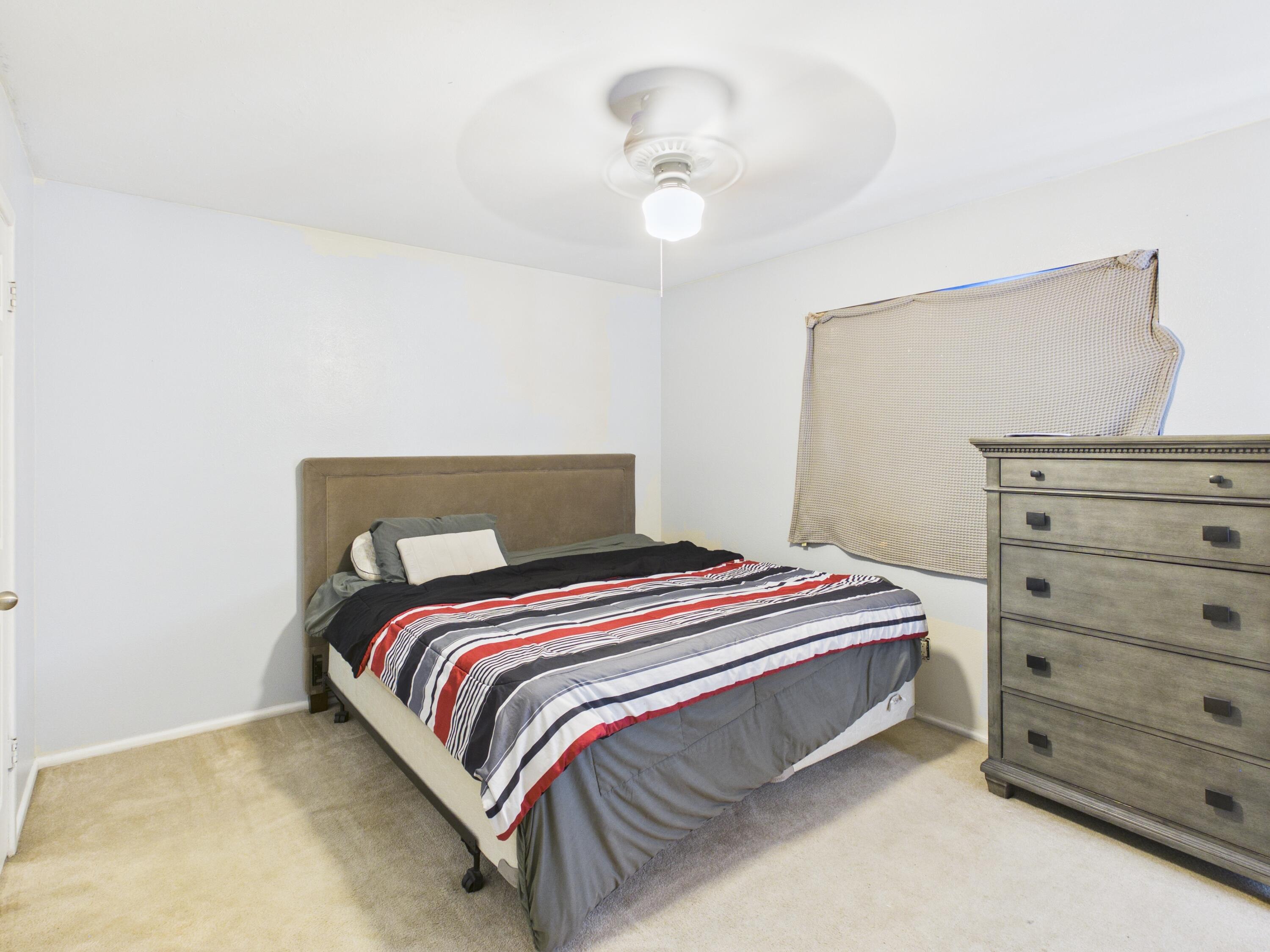 4825 10th Street Lubbock, TX 79416 - Photo 17 of 27 a bedroom with a bed and a dresser