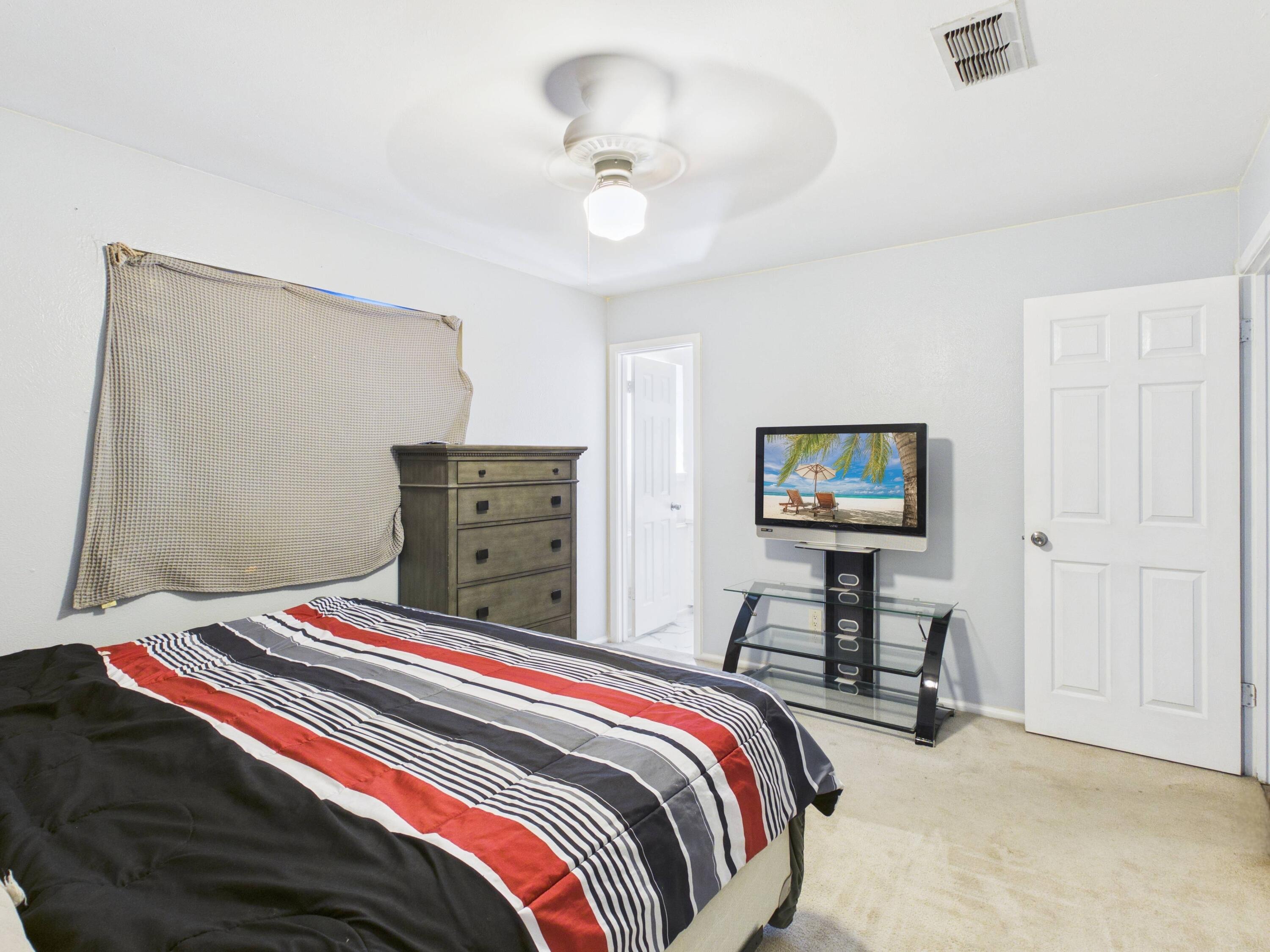 4825 10th Street Lubbock, TX 79416 - Photo 18 of 27 a bedroom with a bed and a chandelier