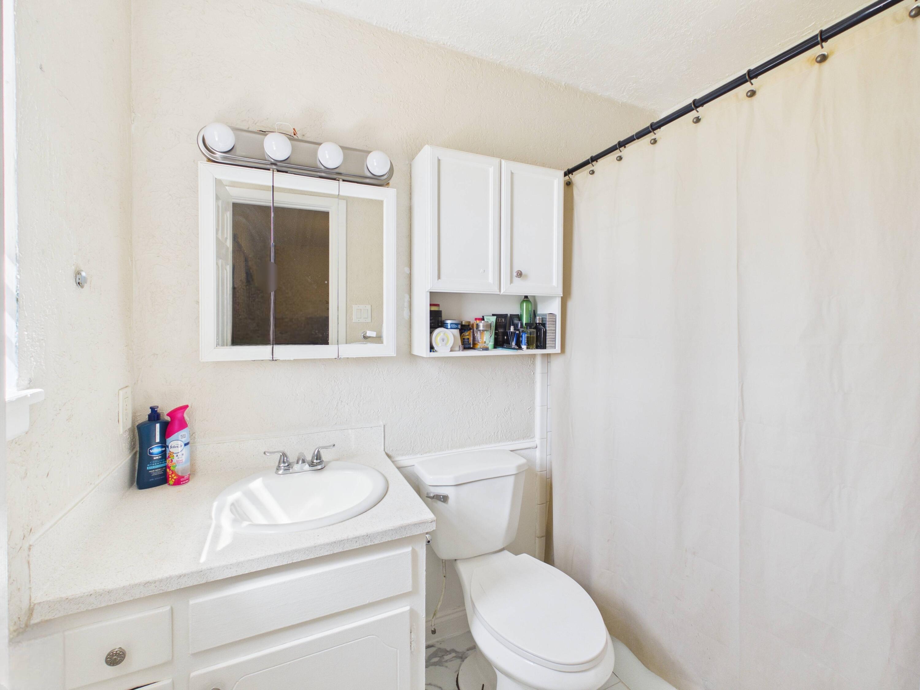 4825 10th Street Lubbock, TX 79416 - Photo 19 of 27 a bathroom with a sink vanity mirror and toilet