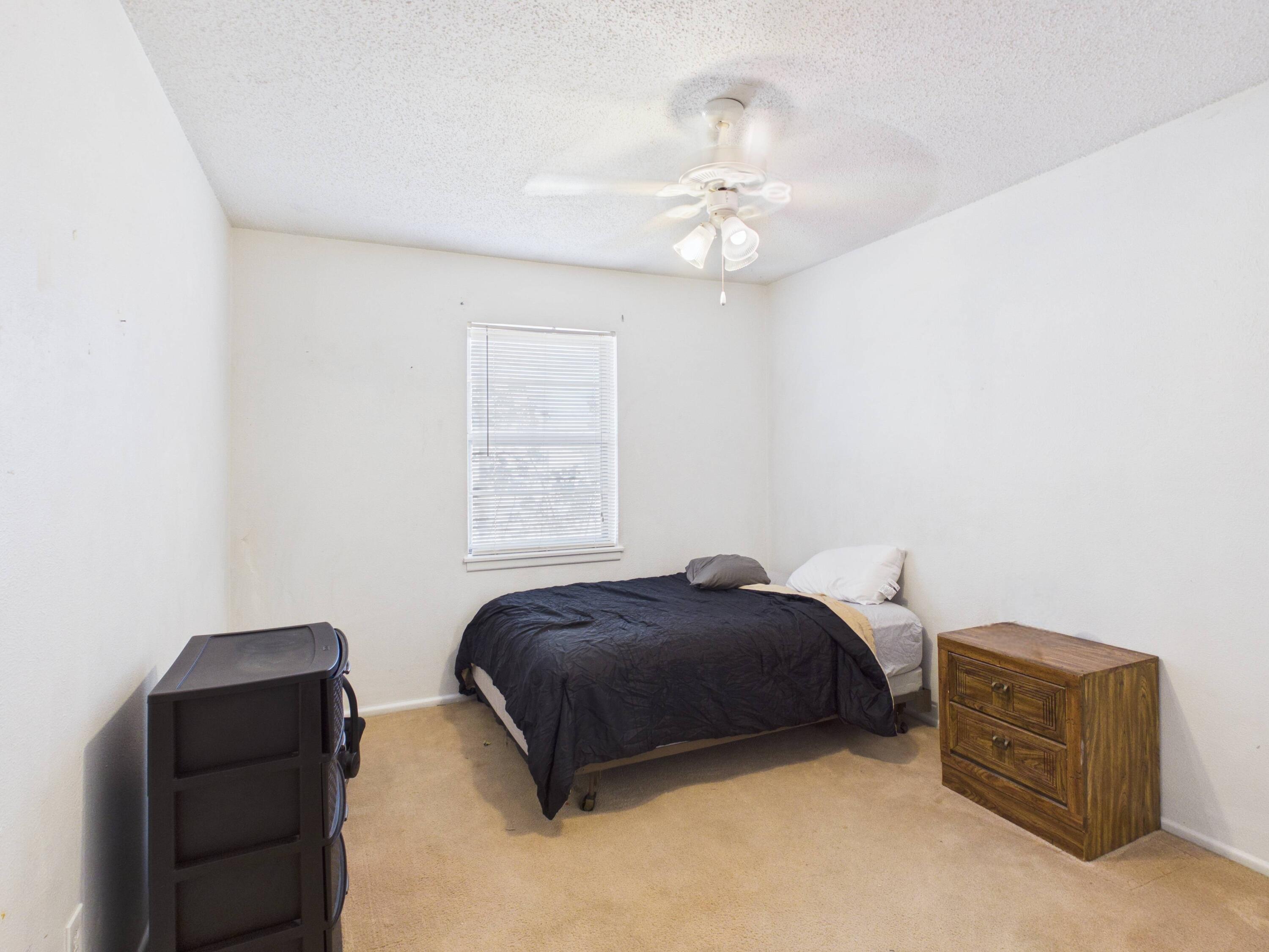 4825 10th Street Lubbock, TX 79416 - Photo 20 of 27 a bedroom with a bed and a chandelier