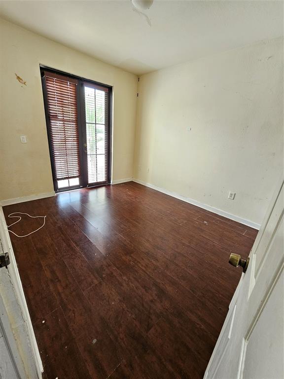 23519 Southwest 112th Court Homestead, FL 33032 - Photo 4 of 19 an empty room with wooden floor and windows