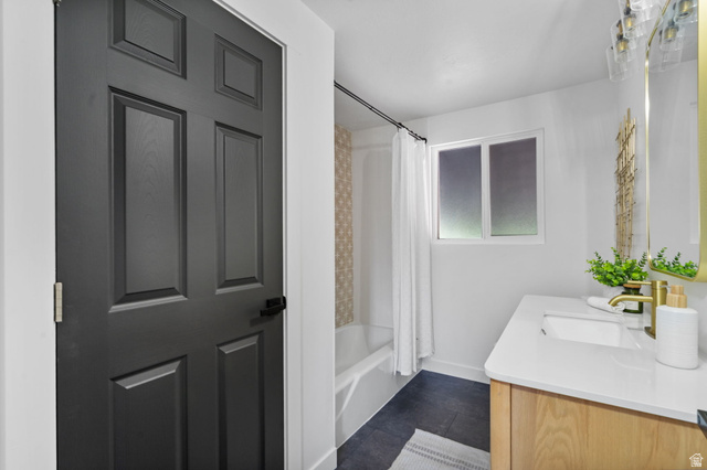 432 Calnette Drive Sandy, UT 84070 - Photo 19 of 48 Bathroom featuring a light wood-finish vanity with a white countertop and undermount sink, a gold-tone faucet, and dark tile flooring