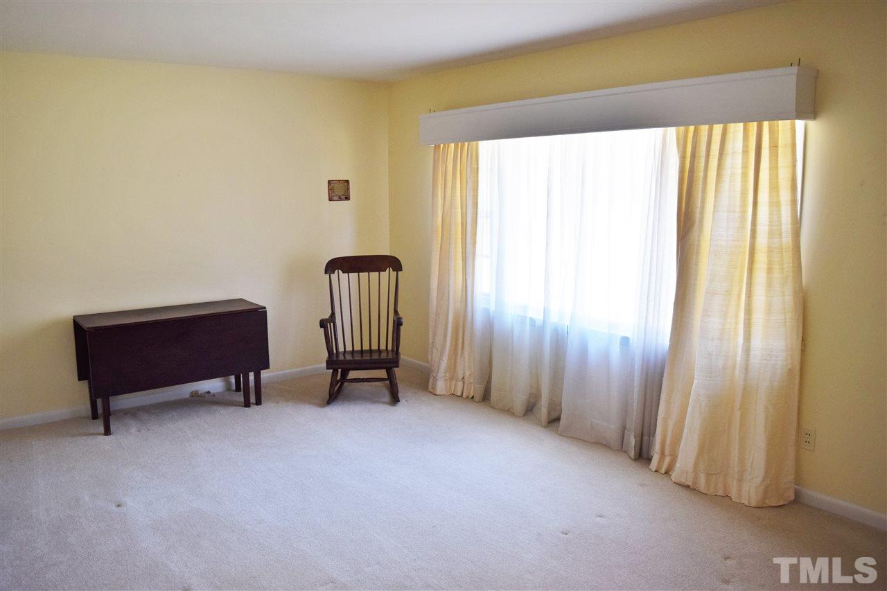 405 Winterlochen Road Raleigh, NC 27603 - Photo 3 of 25 a view of a room with a window and a chair
