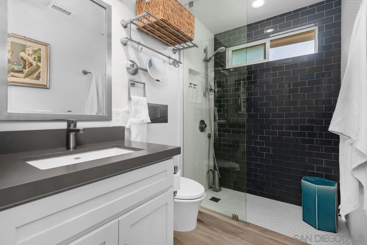 763 Snapdragon Street Encinitas, CA 92024 - Photo 14 of 22 a bathroom with a granite countertop sink a toilet and shower