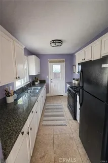 a large kitchen with a stove a refrigerator and a sink