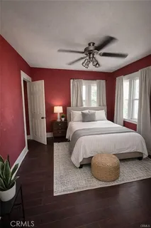 a bedroom with a large bed chandelier and a window