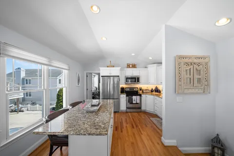 a kitchen with a refrigerator and wooden floor
