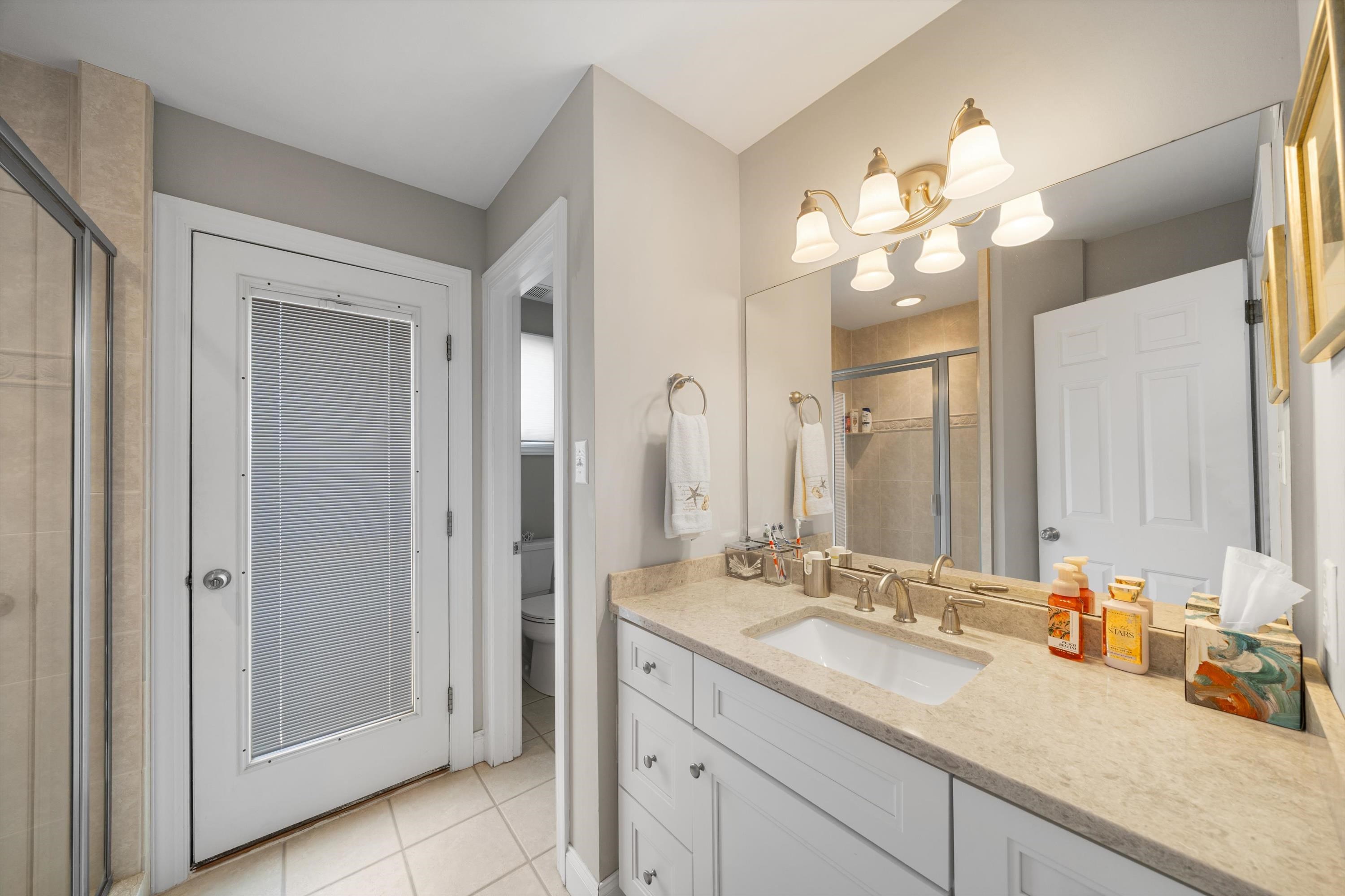 8222 3rd Avenue, Unit NORTH Stone Harbor, NJ 08247 - Photo 23 of 32 a bathroom with a granite countertop sink and a mirror
