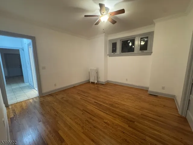 a view of a livingroom with wooden floor and a ceiling fan