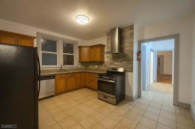 a kitchen with stainless steel appliances granite countertop a refrigerator and a stove top oven