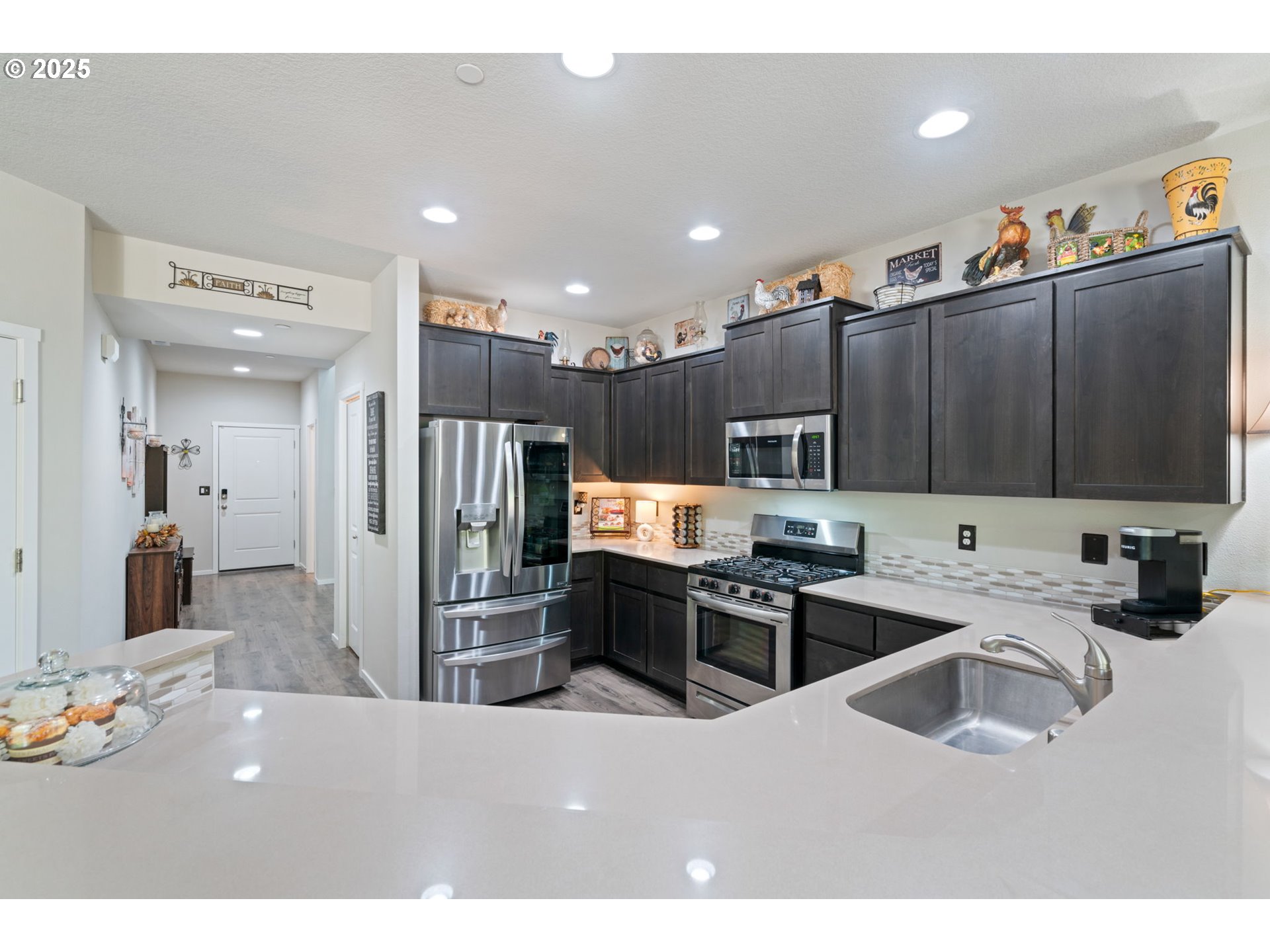 1707 Northeast 37th Avenue Camas, WA 98607 - Photo 13 of 44 a kitchen with stainless steel appliances kitchen island granite countertop a refrigerator oven a sink a dining table and chairs with wooden floor