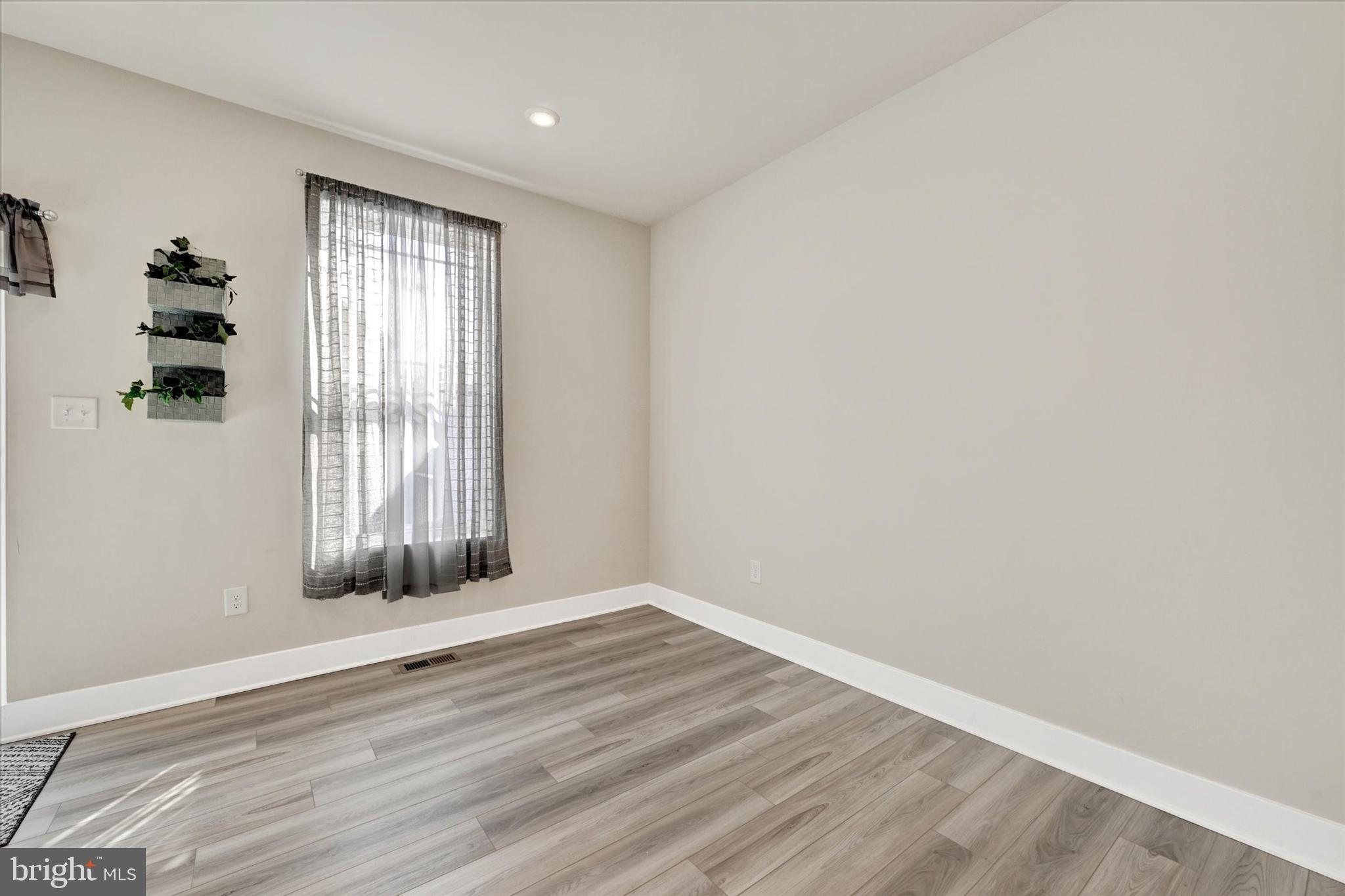 1819 Betterton Road Essex, MD 21221 - Photo 14 of 27 an empty room with wooden floor and windows