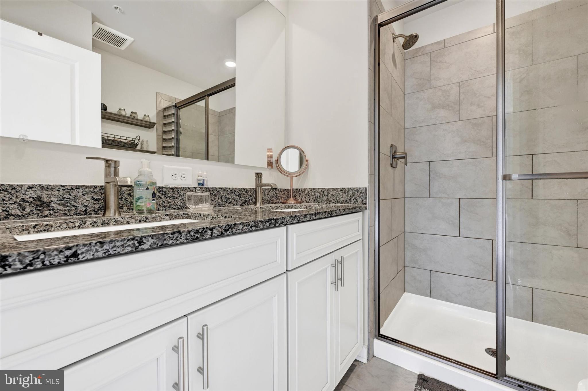 1819 Betterton Road Essex, MD 21221 - Photo 19 of 27 a bathroom with a granite countertop sink a mirror and shower