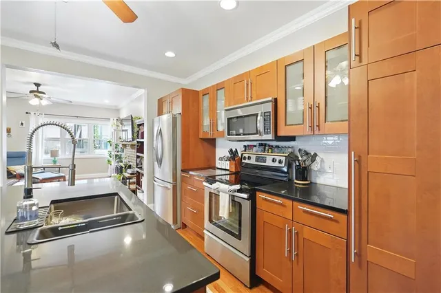 a kitchen with stainless steel appliances granite countertop a stove a sink and a refrigerator