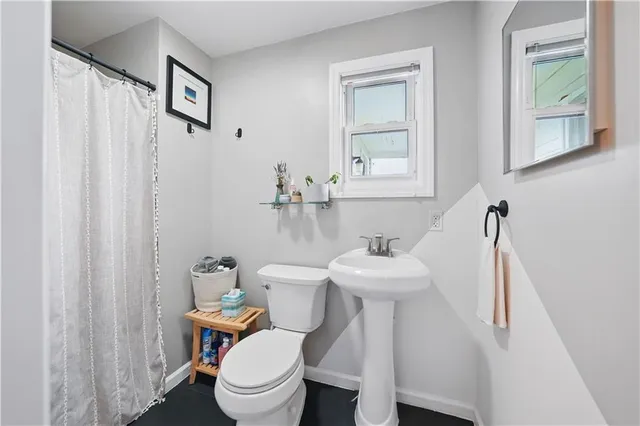 a bathroom with a sink a toilet and a mirror